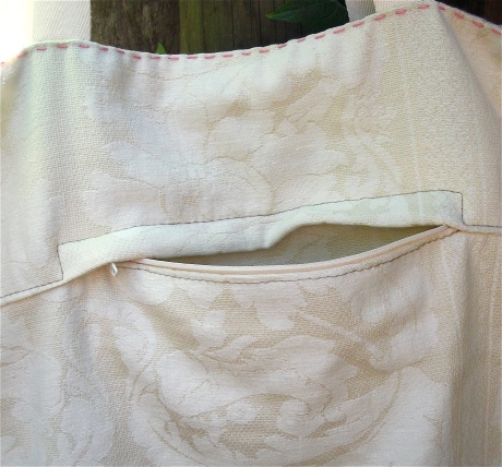 The flipside of the bag is made from reclaimed cream damask and the lining from a soft minty cashmere scarf.